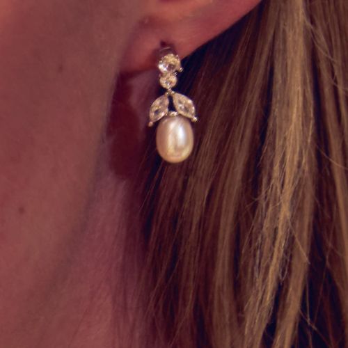 Pair of drop crystal earrings featuring a tear drop natural colour pearl supported by leave and circle shaped crystals. 