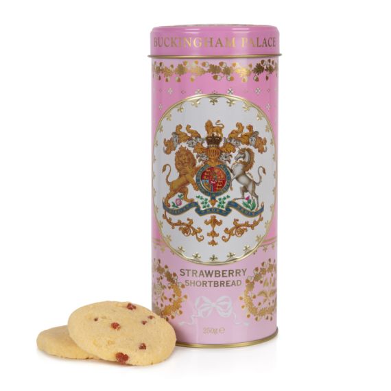 pink biscuit tin with the crest at the centre of the tin. Stood next to a few biscuits pink biscuit tin with the crest at the centre of the tin. Stood next to a few biscuits